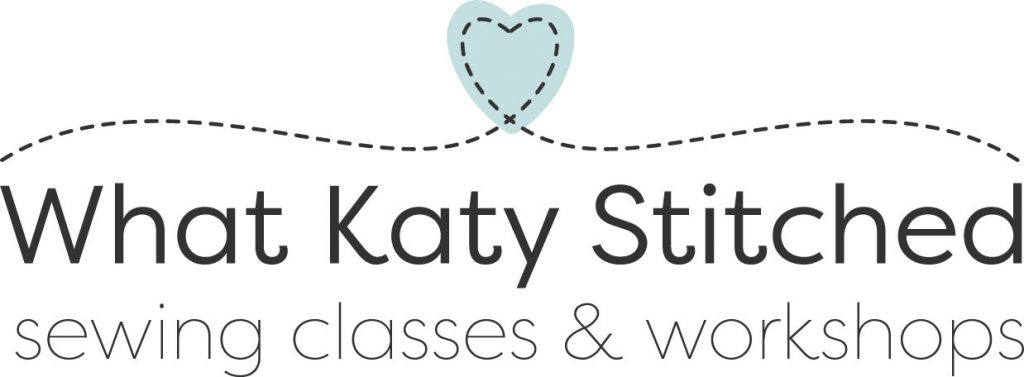what katy stitched logo which is topped with a blue heart and a line of stitching that looks like it is hugging the text with strapline of sewing classes & workshops